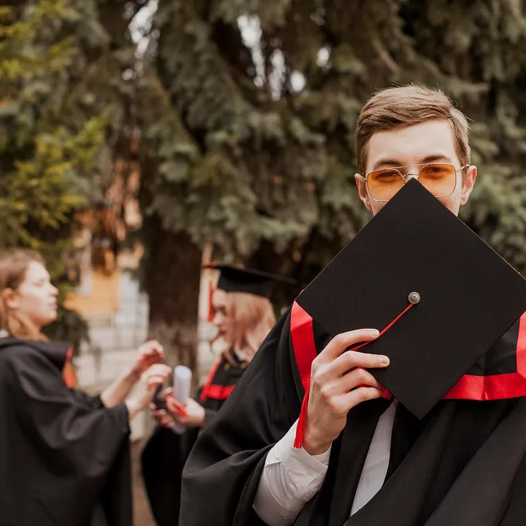 Graduate holding a mortarboard